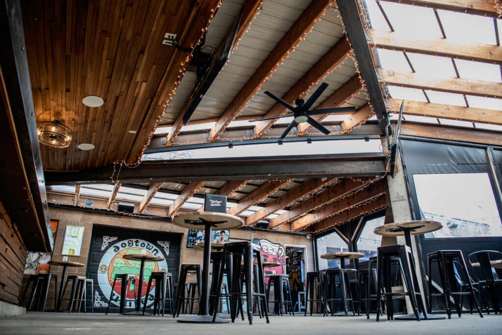 Under the patio roof — string lights, ceiling fans, and the Dogtown mural