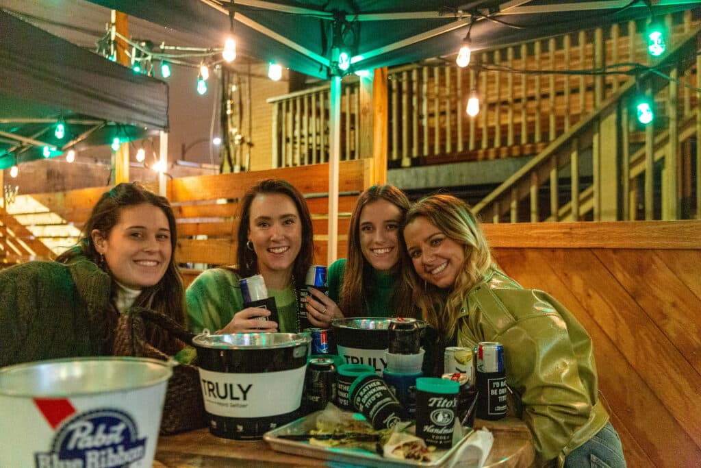Late-night crew with buckets of cans under the umbrella