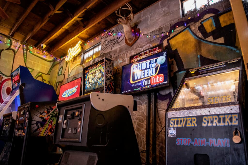 Arcade cabinets under the deer mount and the Shot of the Week screen