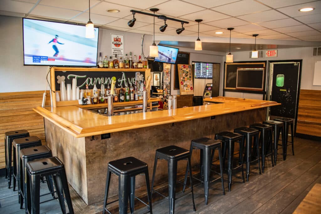 The wooden bar at open — stools ready, Tamm Ave on the chalkboard