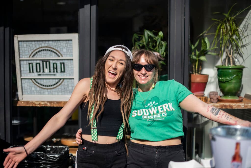 Two friends in green, laughing out front on parade day