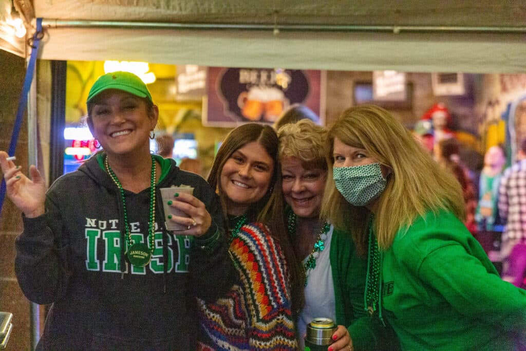 Green beads and big smiles inside the bar