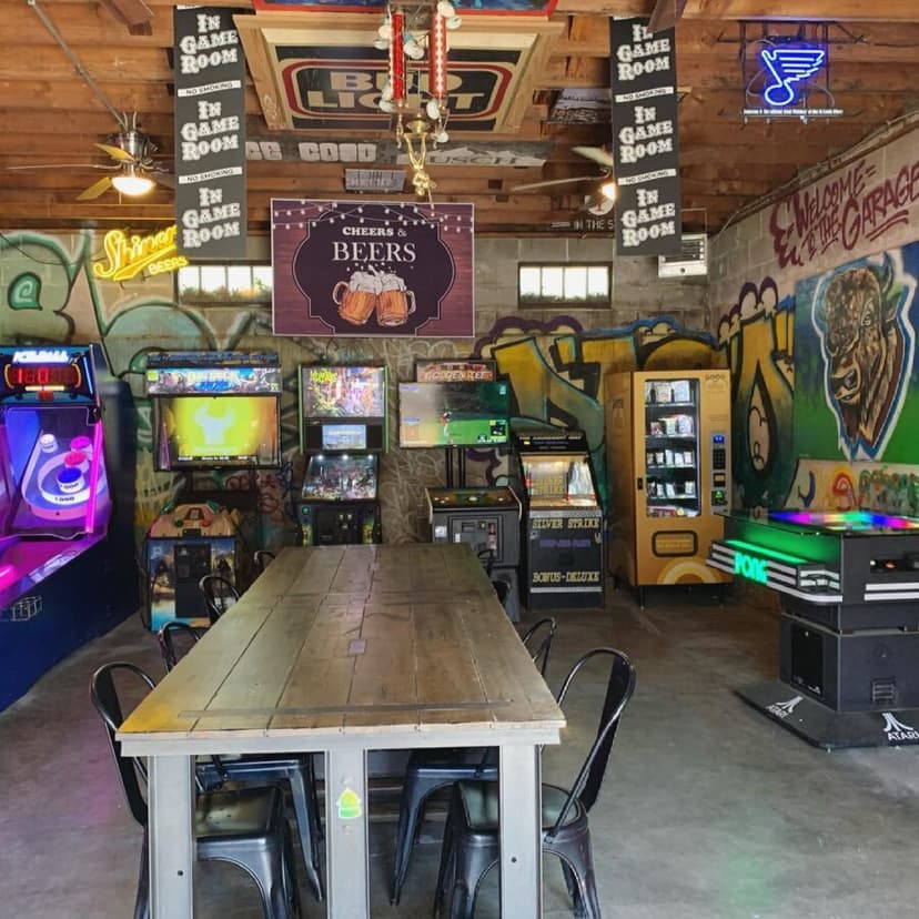 The game room: arcade cabinets, graffiti walls, and a neon sign