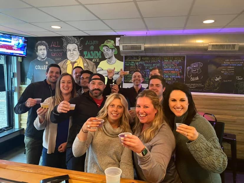 Friends raising a toast together in front of the chalkboard wall