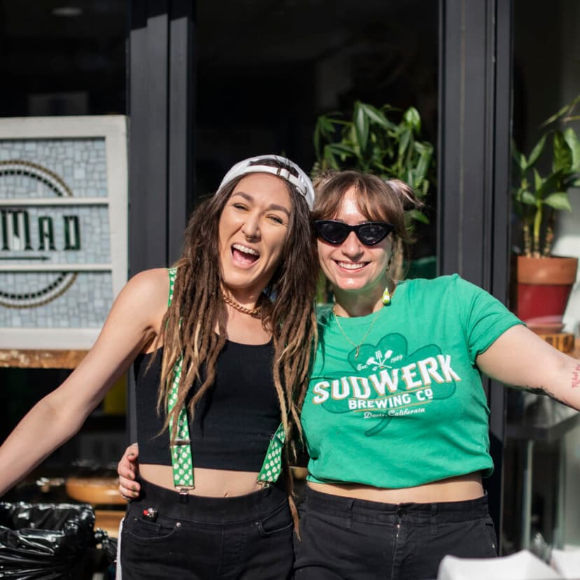 Two friends in green laughing outside on St. Patrick's Day